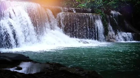 Serene Multi-Tiered Waterfall Cascading into a Tranquil Pool Stock Footage 301087775