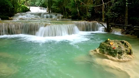 Serene Multi-Tiered Waterfall Cascading Through Lush Green Tropical Forest Stock Footage 301088181