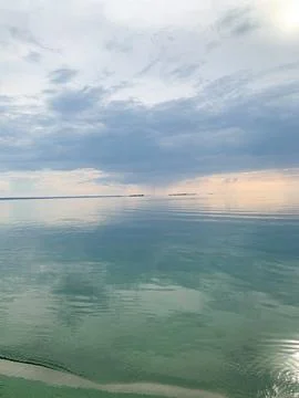 Serene ocean horizon with dramatic clouds and calm, reflective water surface Foto stock