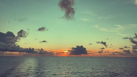 Serene ocean horizon at sunset with dramatic clouds and a colorful sky Stock Footage 338282519