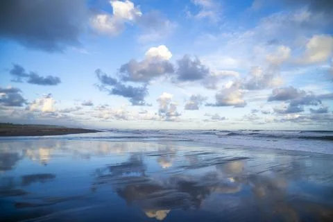 Serene Ocean Reflections Beneath Dramatic Coastal Clouds Foto stock