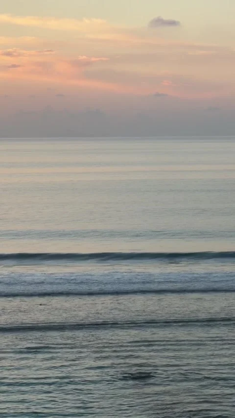 Serene ocean sunset with soft pastel clouds over calm waves Stockbeeldmateriaal 334084792