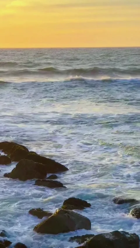 A serene ocean video at sunset with waves crashing on rocky shores Vídeos de archivo 333021928