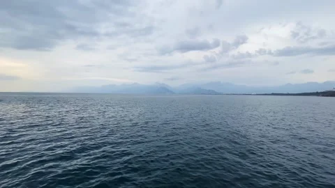 Serene Ocean View With Distant Mountains on a Cloudy Day Stock Footage 267571139