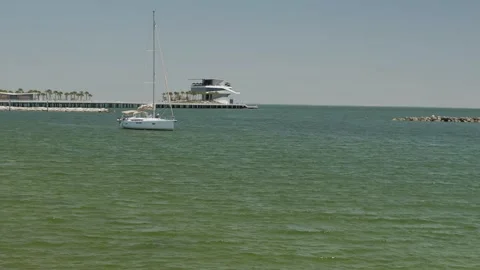 Serene ocean view featuring a pier extending into the water, surrounded by a pea Stock Footage 306882937