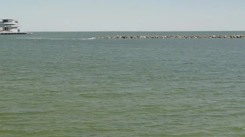 Serene ocean view featuring a pier extending into the water, surrounded by a pea Stock Footage 306882948