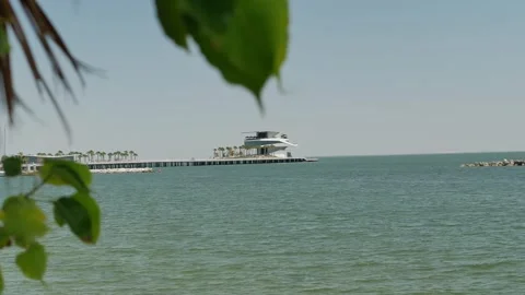 Serene ocean view featuring a pier extending into the water, surrounded by a pea Stock Footage 306883034