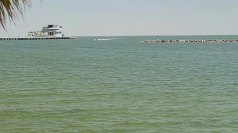 Serene ocean view featuring a pier extending into the water, surrounded by a pea Stock Footage 306883141