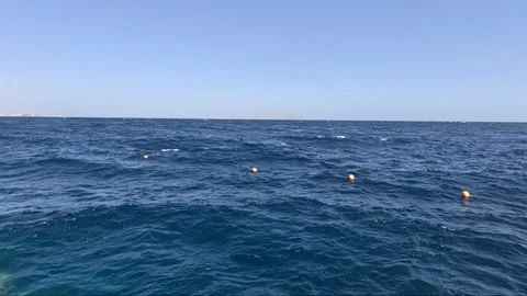 A Serene Ocean View with Gentle Waves and Floating Buoys in the Distance Under a Видео 330100260
