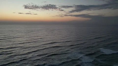 Serene ocean waves at dawn with dramatic clouds painting the sky. Stock Footage 333472282