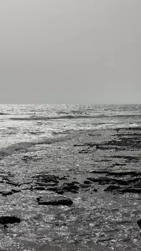 Serene Ocean Waves Gently Breaking on the Rocky Shoreline in Beautiful Stock Footage 319008740