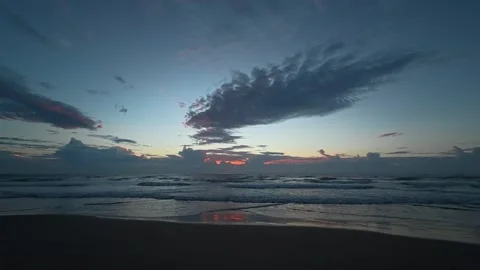 Serene ocean waves gently lap the shore under a dramatic twilight sky. 動画素材 333136946