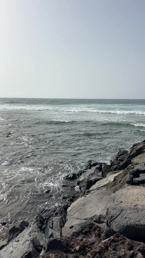 The Serene Ocean Waves Gently Rolling Over the Rocky Shores Create a Peaceful Stock Footage 319008669