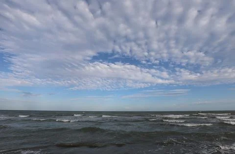 Serene ocean waves under dramatic cloudy sky landscape Stock Photos