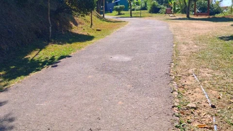 Serene park pathway with trees benches and grass Vídeo Stock 331657567