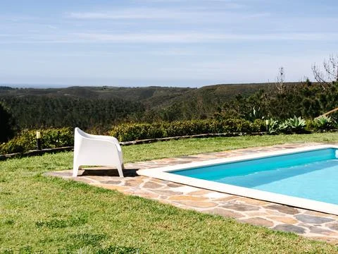 A serene poolside setting with white lounge chairs overlooking a panoramic vi Stock Photos