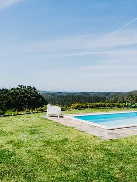 A serene poolside setting with white lounge chairs overlooking a panoramic vi Stock Photos