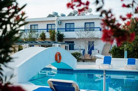 Serene Poolside with White Bridge and Blue Loungers Stock Photos