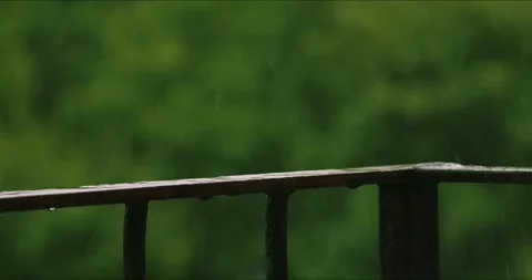 Serene Rain Falling on Balcony Railing brings calmness and peace, creating a Stock Footage 277745625