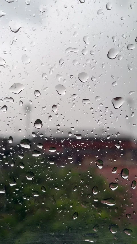 Serene Raindrops Falling on Window Glass with Blurred Nature Background Stock Footage 340989893