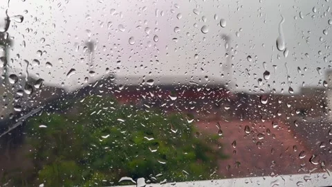 Serene Raindrops Falling on Window Glass with Blurred Nature Background Stock Footage 340989900