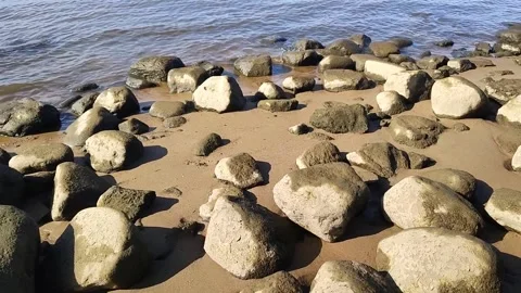 Serene river beach landscape, showcasing massive boulders on sandy shores Stockbeeldmateriaal 318211890