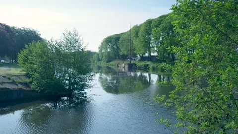 Serene river flowing through lush green european landscape Stock Footage 336902924