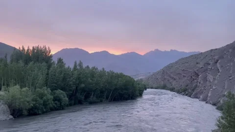 Serene river flowing through mountains at sunset Stock Footage 324127585