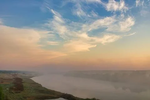 Serene river landscape with sky and clouds during sunset Stock Photos