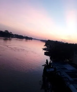 Serene river landscape at sunset with soft purple light reflecting on calm .. Stock Photos