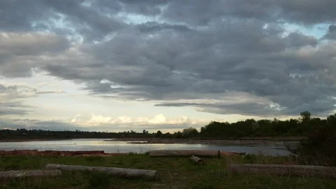 Serene River Landscape Under a Dramatic Cloudy Sky at Dusk Stock Footage 274463857