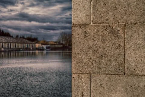 A serene river with the rough texture of a stone wall Stock Photos