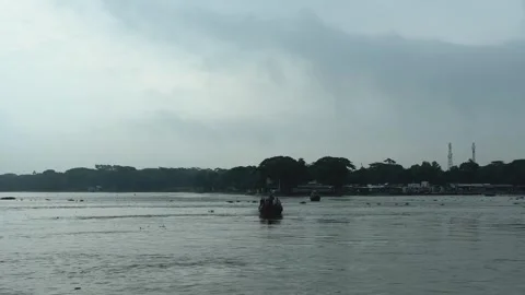 Serene river scene with distant boat under cloudy sky and lush green shorel.. Stock Footage 340056135