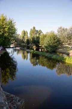 A serene river scene featuring a small stone dam Stock Photos