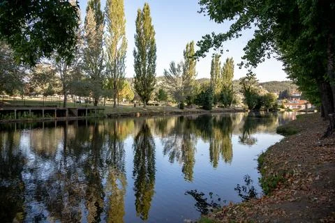 A serene river scene featuring a small stone dam Stock Photos