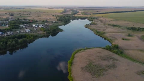 A serene river weaving through lush fields in a beautiful landscape, seen from a Stock Footage 281869808