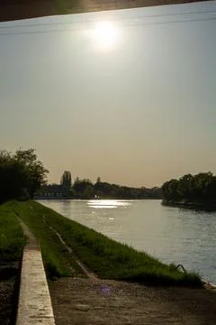 Serene riverside view with sunlight reflection Stock Photos