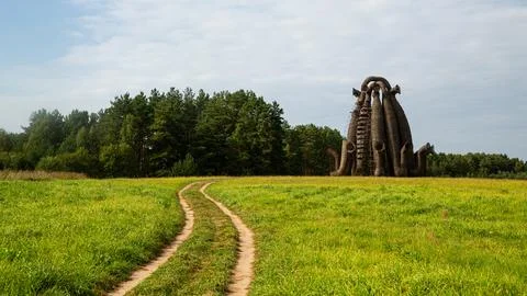 A serene rustic pathway leading to a unique wooden sculpture in a picturesque Stock Photos