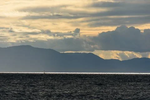 A serene scene featuring a deep blue ocean under dramatic overcast skies wi.. Stock Photos