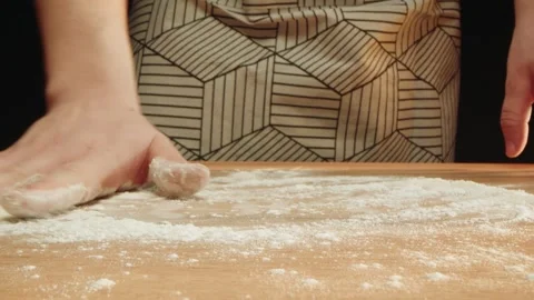 Serene scene of flour being spread on rustic table in cozy kitchen setting Video stock 331846439