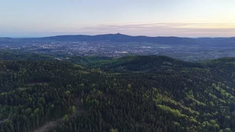 Serene scene over distant illuminated city. Calm landscape of hills at sunset Stock Footage 342360088