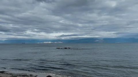 Serene seascape with distant mountains under a cloudy sky. Roda beach, Stock Footage 294970566
