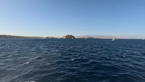 Serene Seascape: A Tranquil View of Waves and Rocky Islands Under a Clear Sky Видео 331058345