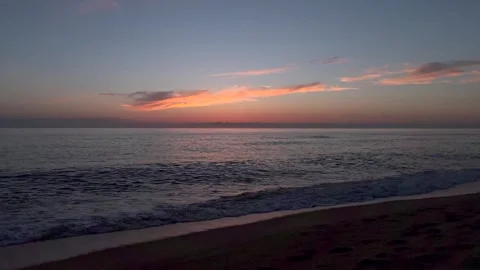 Serene seaside sunset with soft surf and glowing horizon. Warm evening colors Stock Footage 337104912