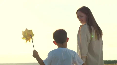 Serene setting park sunset mother lovingly clasps son hand. joyful family Stock Footage 247499366