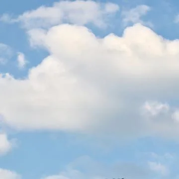 A serene sky background featuring a large, fluffy cumulus cloud that domina.. Photos