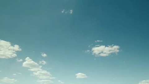 A Serene Sky Filled with Fluffy Clouds Set Against a Clear and Bright Blue Backg Stock Footage 310576940