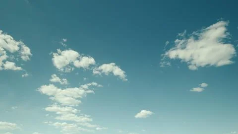 A Serene Sky Filled with Fluffy Clouds Set Against a Clear and Bright Blue Backg Stock Photos