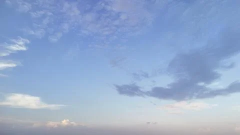 A serene sky filled with soft clouds in shades of blue and white, creating a Stock Photos