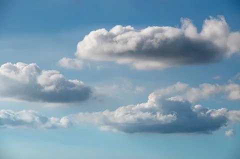 Serene Sky: Fluffy White Clouds on a Blue Canvas. Stock Photos